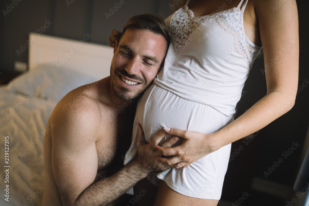 Happy pregnant woman enjoying with husband in bedroom Happy pregnant woman enjoying with husband in bedroom