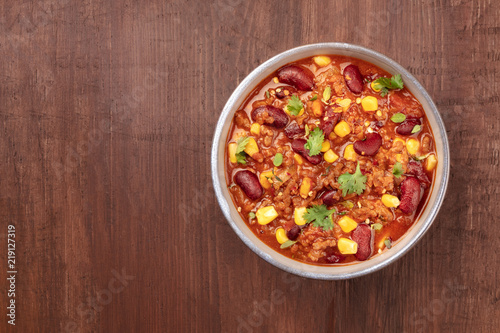 Chili con carne, traditional Mexican dish, overhead photo with copyspace