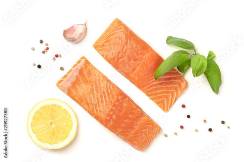 Slices of salmon with lemon, basil, garlic, and pepper, on a white background with copy space, overhead photo