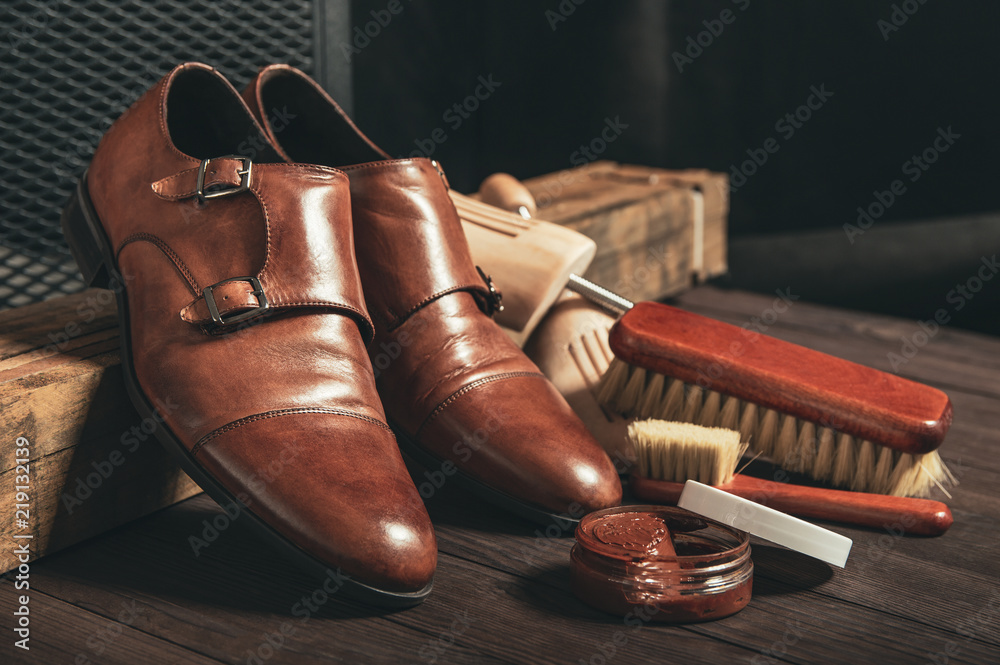 Leather shoes and shoe polish equipment on a wooden composition - obrazy, fototapety, plakaty 