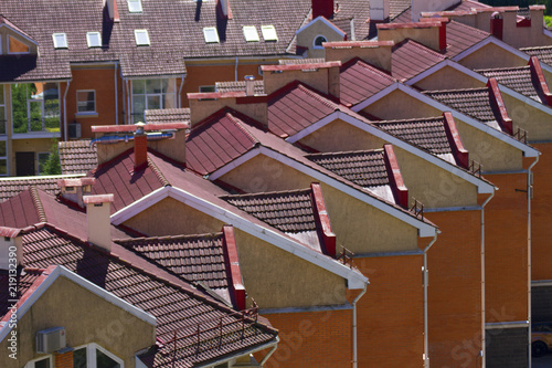 Red roof of townhouses. Beautiful townhouses in a row with orange facade on a sunny day