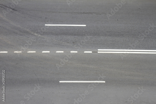 Asphalt road with white stripes. Dark gray urban asphalt road background texture