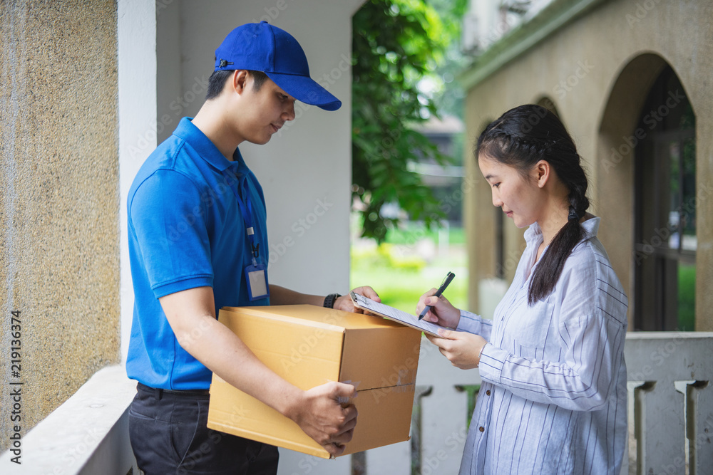 woman is signing to receiving parcels from courier. woman is signing to receiving parcels from courier.