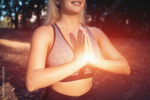 Obraz na plátně young beautiful female meditate in lotus position in green park;