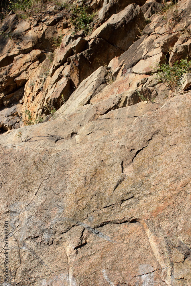 Granite rocks in the sun. Texture of granite stone. Background of natural material. Rocky rocks of ancient times Granite rocks in the sun. Texture of granite stone. Background of natural material. Rocky rocks of ancient times