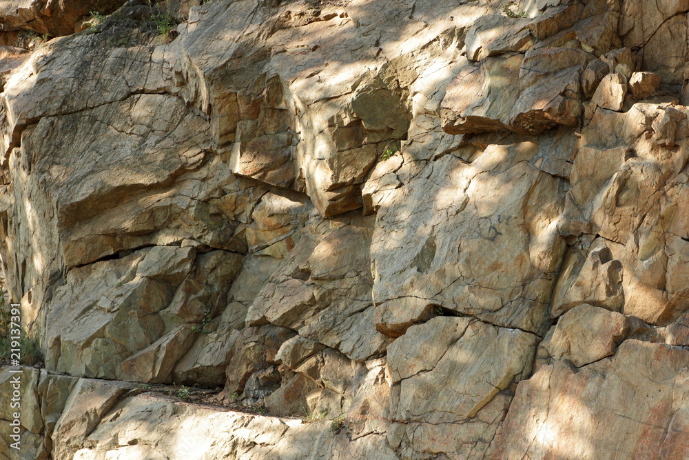 Granite rocks in the sun. Texture of granite stone. Background of natural material. Rocky rocks of ancient times