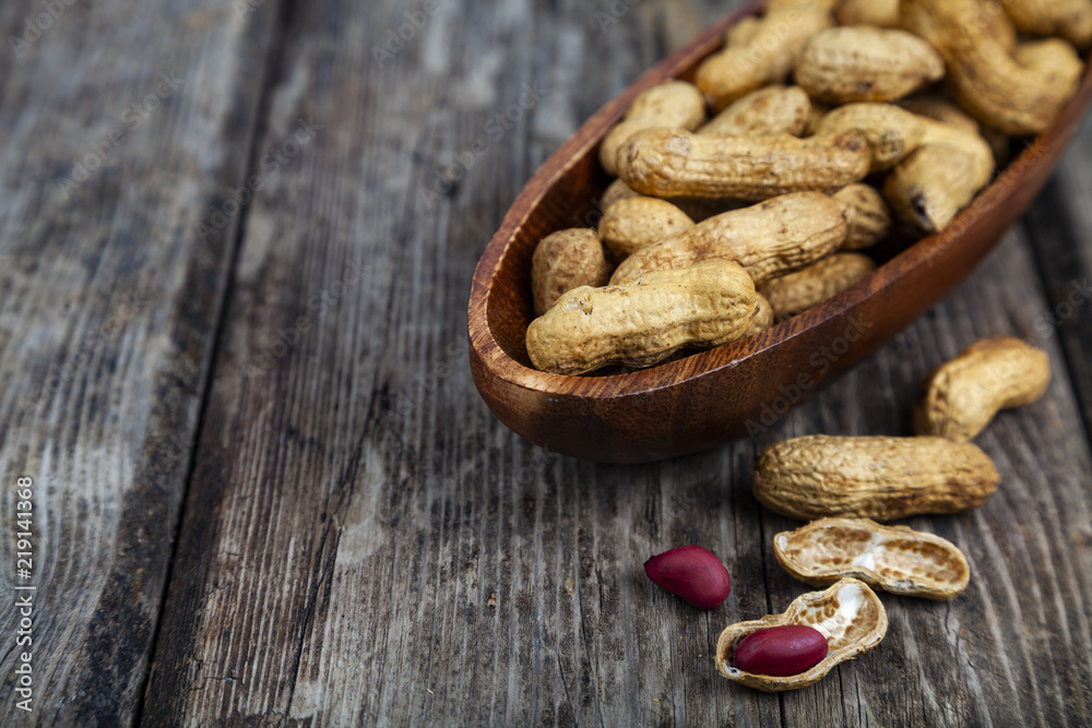 Fototapeta premium Peanuts in a wooden bowl