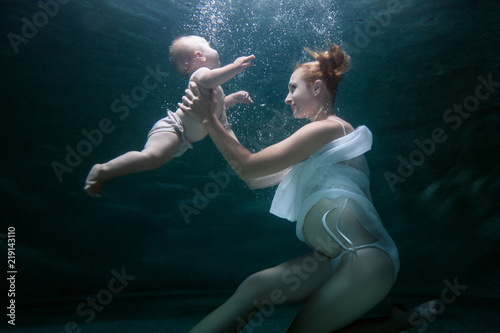 Mom trains an infant to dive under water.
