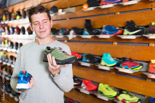 Adult man chooses shoes in shop