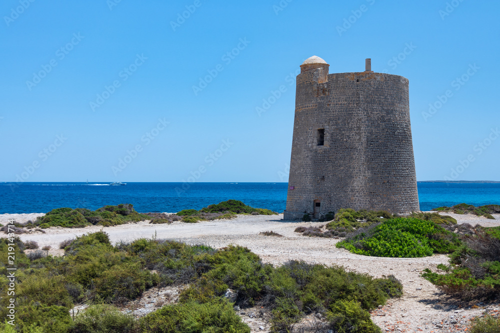 seascape with an old tower and a speeding boat on the sea Ibiza