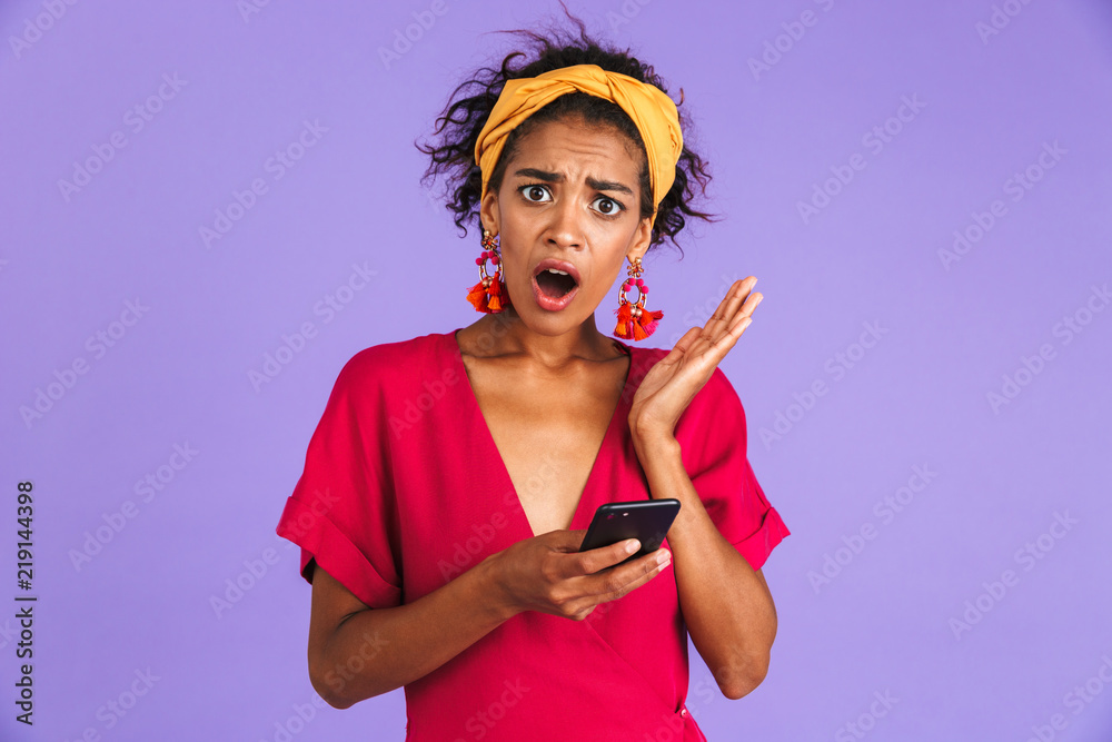 Shocked african woman in dress looking at the camera Shocked african woman in dress looking at the camera