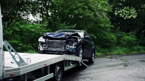 A crashed car being put on a tow truck after an accident. photo