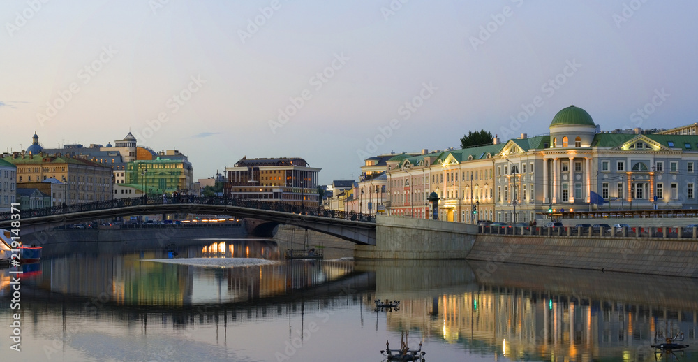 Evening panoramic view of the embankment and the bridge in Moscow: Central district, Bolotnaya square, calm water
