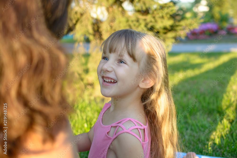 happy daughter with wother sit in the city park at summer happy daughter with wother sit in the city park at summer