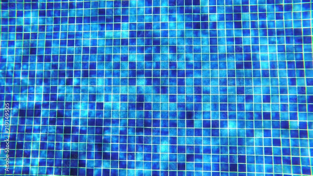Abstract background. Underwater shoot of blue tile in swimming pool with shiny sunlight reflection.