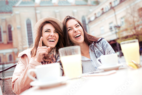 Two friends have a good time in sunny cafe