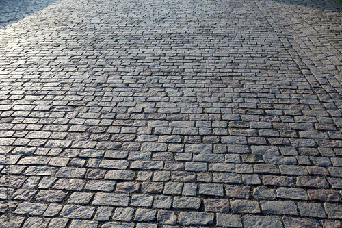 Stone paving stone in the light of the sunrise in Prague
