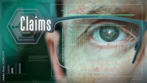 A close up of a businessman eye controlling a futuristic computer system with an Claims concept.