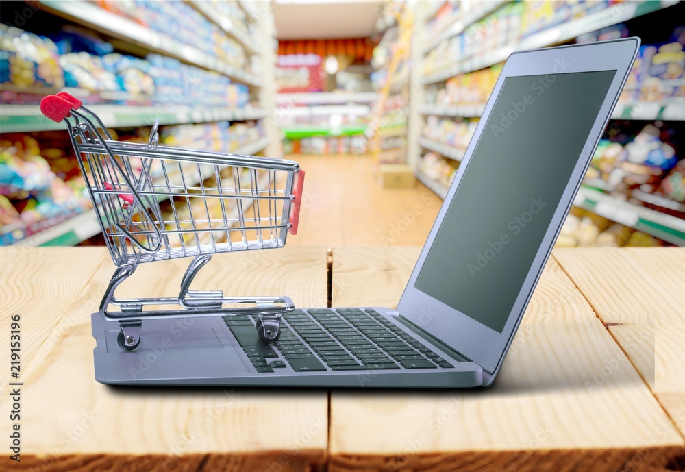 Shopping-cart over a laptop on desk