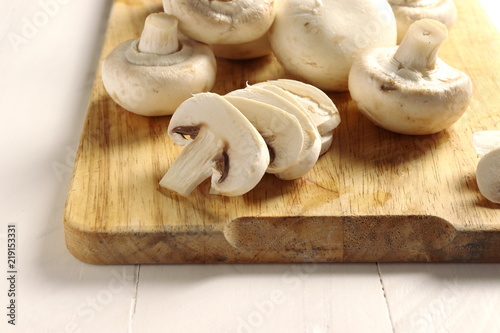 Sliced champignons on wooden cutting board, closeup