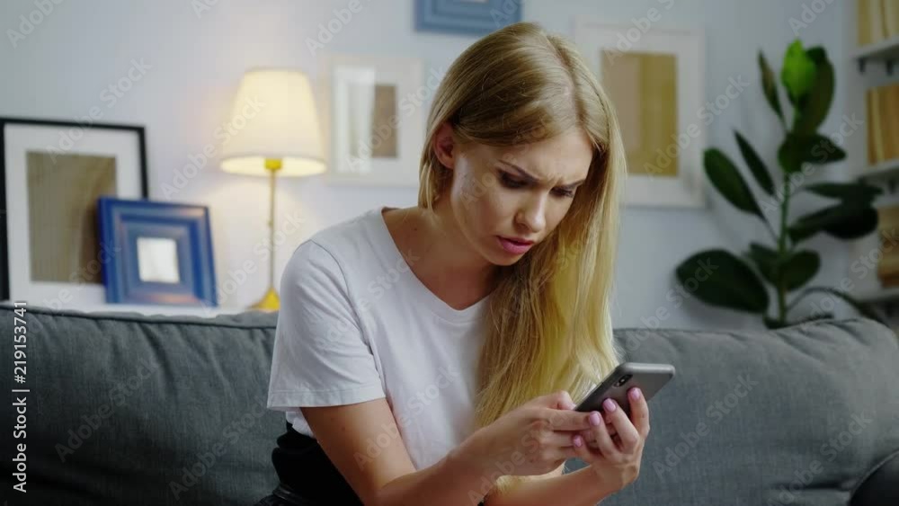 Beautiful woman using her smartphone in the living room Beautiful woman using her smartphone in the living room