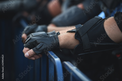  Security staff hands on a protection fence during a riot