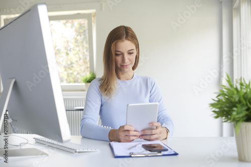 Businesswoman using digital tablet while working in the office