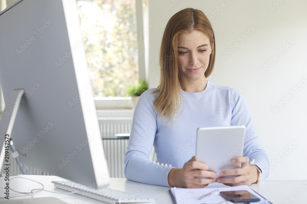 Businesswoman using digital tablet while working in the office Businesswoman using digital tablet while working in the office