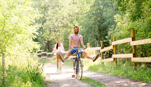 cycling, leisure and lifestyle concept - happy young couple with bicycles at summer park #219157574