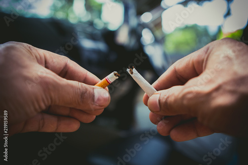 Cigarette being broken in two pieces by man stop smoking stop addiction