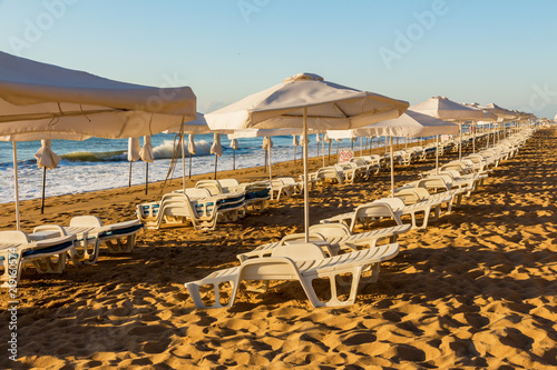 Fototapeta Naklejka Na Ścianę i Meble -  empty morning beach with sun beds and umbrellas from the sun