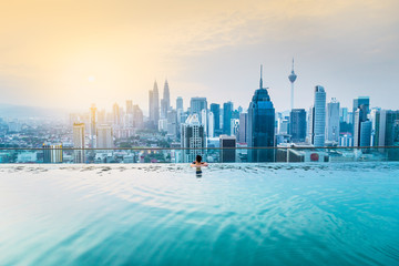 Tableau sur plexiglas Kuala Lumpur Homme d'affaires piscine rooftop Kuala Lumpur aube  © sakarin14