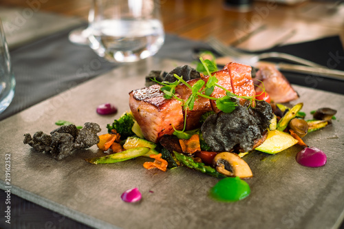 Mini tuna steaks with salad potato side dish and vegetables on ceramic plate