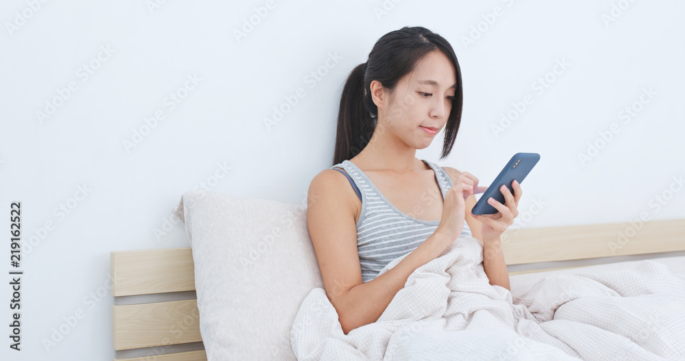 Woman use of mobile phone on bed Woman use of mobile phone on bed