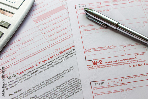 W-2 and W-3 filing forms as well as a calculator and pen