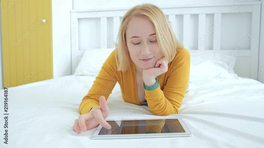 Beautiful blond European female scrolling something using digital tablet PC Beautiful blond European female scrolling something using digital tablet PC