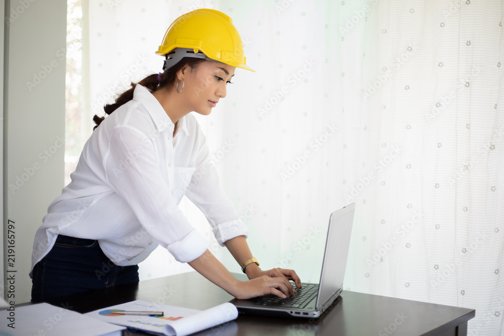 Asian women engineering inspecting and working and holding blueprints at office Asian women engineering inspecting and working and holding blueprints at office