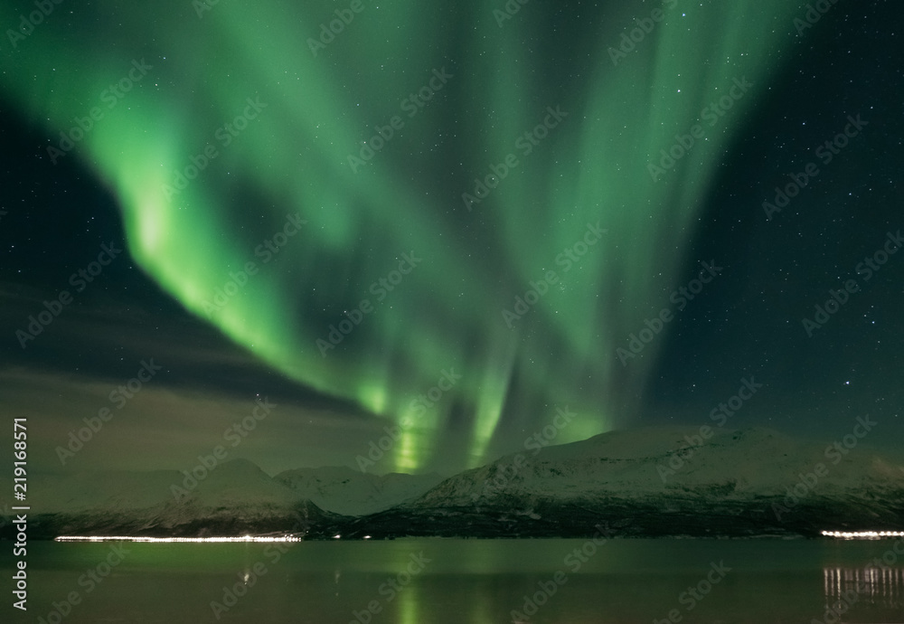 Landscape of northern lights over the Norway fjord in winter.