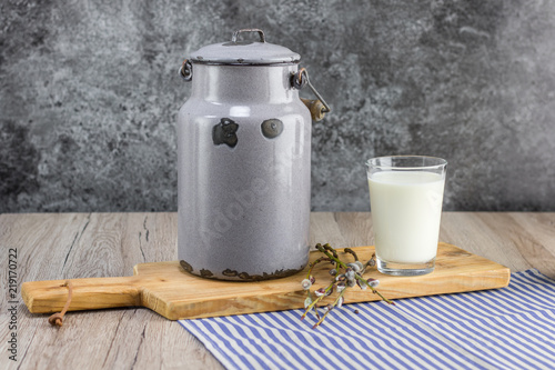 Fresh unpasteurized milk in a old milk jug and glass jar