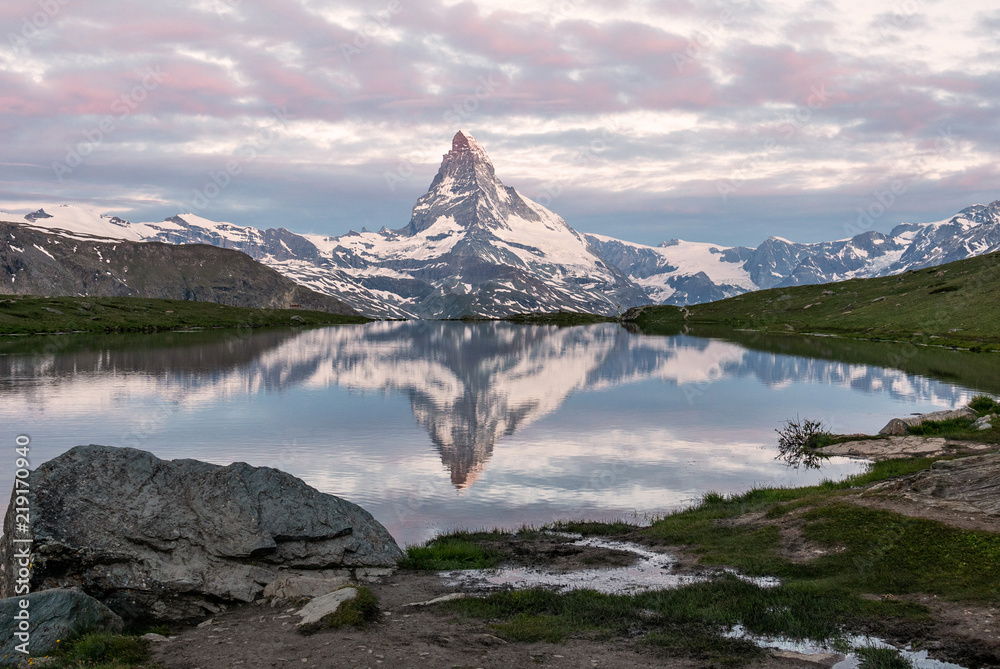 Naklejka premium Very early morning shot of the Matterhorn (Monte Cervino, Mont Cervin) pyramid and Stellisee lake. Blue hour before sunrise. Great june outdoor scene in Swiss Alps, Zermatt, Switzerland, Europe.