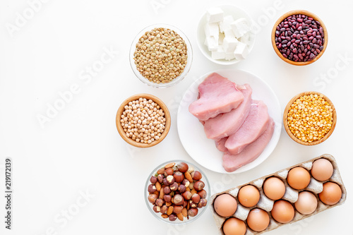 Healthy food. Products rich protein and fiber. Legumes, nuts, low-fat cheese, meet, eggs. Raw beans, chickpeas, lentil, almond, hazelnut on white background top view copy space