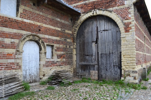 Photograph of a gate of old brick-and-limestone stables. Taken at Park Abbey  Leuven  Belgium.