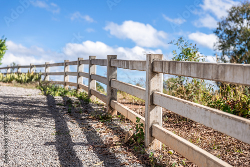 Long range of outdoor grunge concrete fence cover and separate the land on hill in countryside with cloudy blue sky and sunlight as environment.