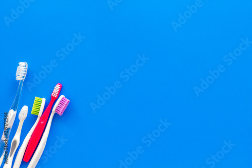 Clean teeth. Toothbrushes on blue background top view copy space