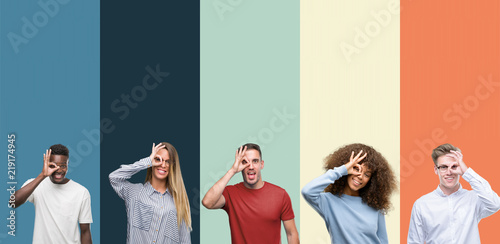 Group of people over vintage colors background doing ok gesture with hand smiling, eye looking through fingers with happy face.