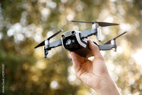 Drone takes off from man hand in park. Technology concept of blogger photographer.