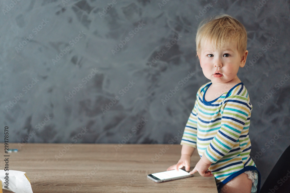 Naklejka premium baby boy standing near the table