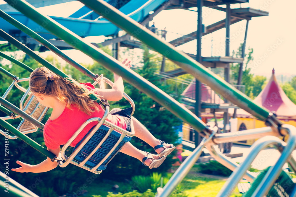 Naklejka premium The girl is riding a carousel at high speed on a swing.