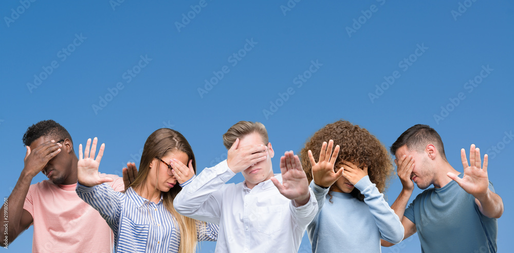 Composition of group of friends over blue blackground covering eyes with hands and doing stop gesture with sad and fear expression. Embarrassed and negative concept. Composition of group of friends over blue blackground covering eyes with hands and doing stop gesture with sad and fear expression. Embarrassed and negative concept.
