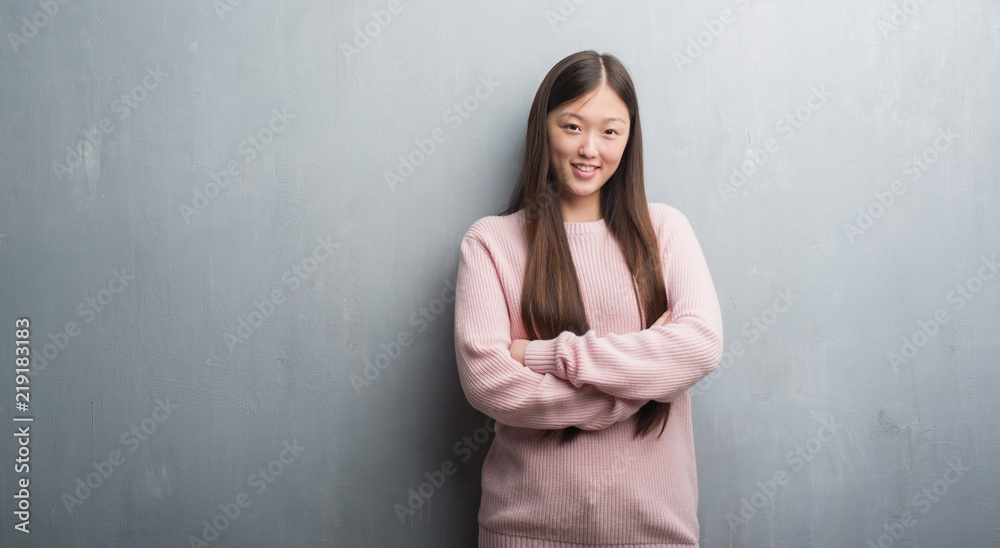 Young Chinese woman over grey wall happy face smiling with crossed arms looking at the camera. Positive person. Young Chinese woman over grey wall happy face smiling with crossed arms looking at the camera. Positive person.